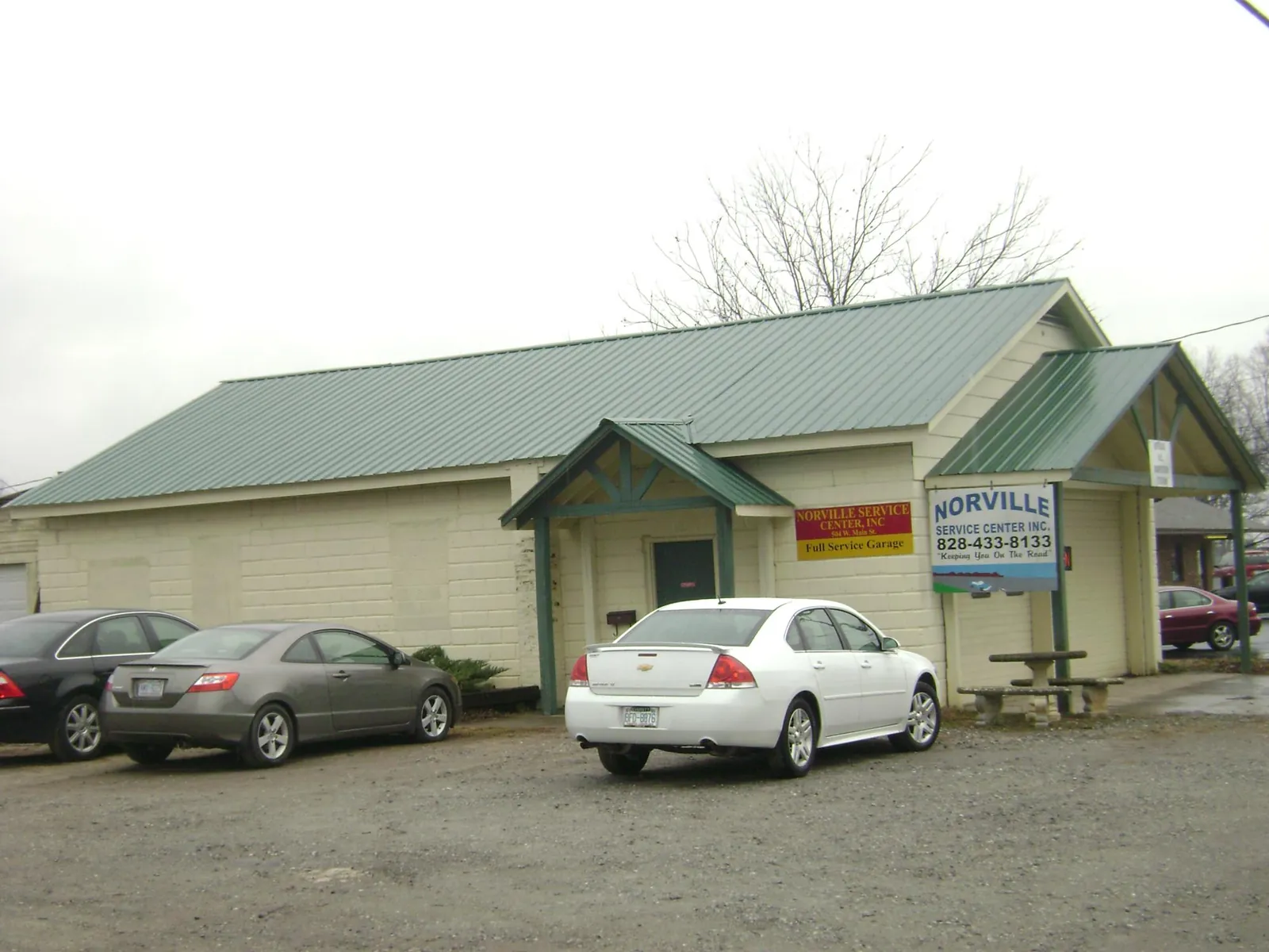 Green metal roof on a service garage with a covered entry in Orange